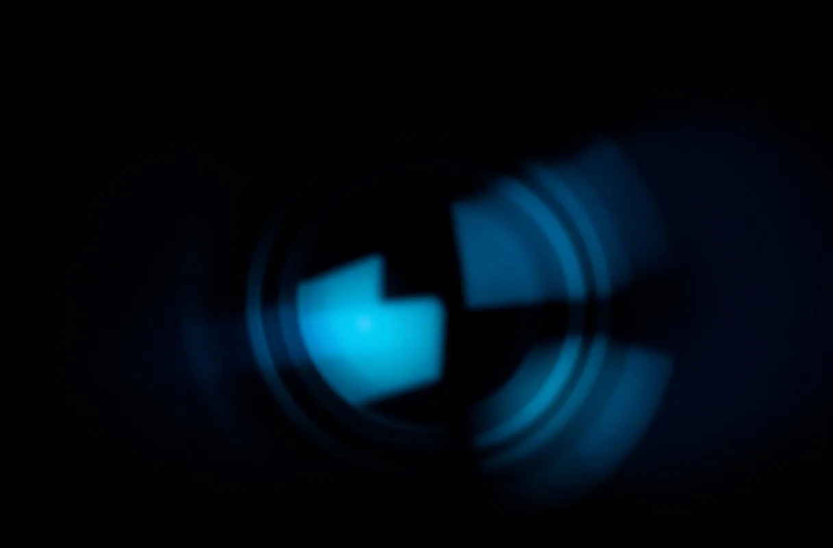 Close-up of a matte black VR headset lens with cool blue reflections, representing Imprint Reality's immersive product